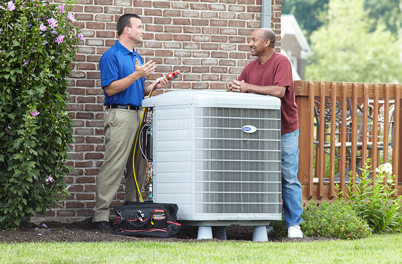 carrier tech talking to client next to ac unit