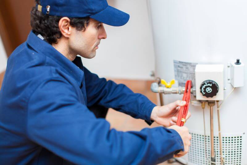 tech repairing water heater